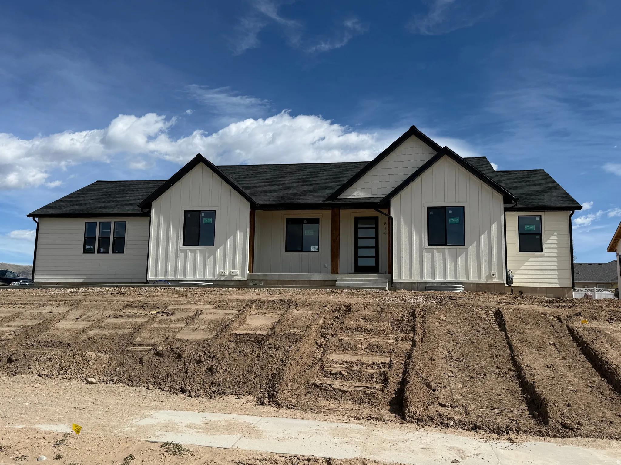 Modern inspired farmhouse with a porch, a shingled roof, and board and batten siding