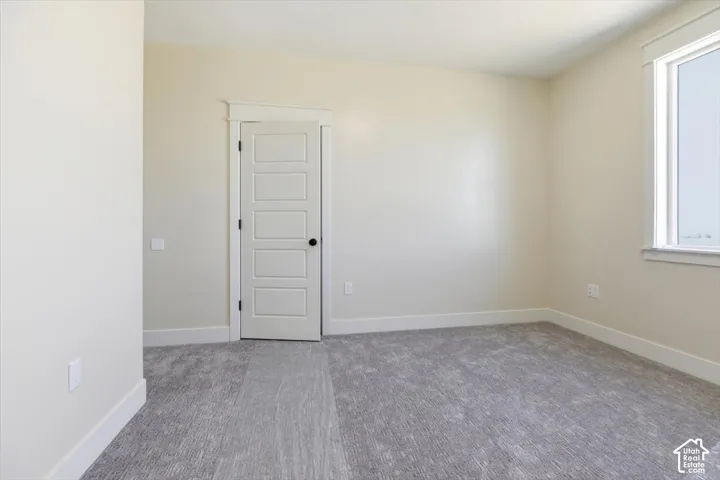 Carpeted empty room with baseboards