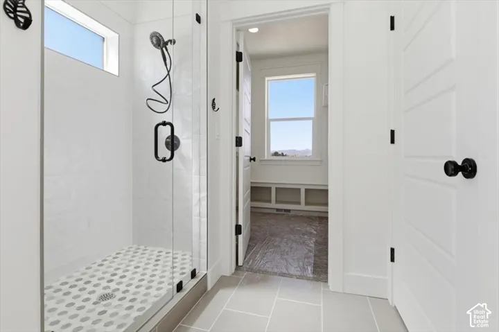 Full bath with a shower stall, plenty of natural light, and light tile patterned floors