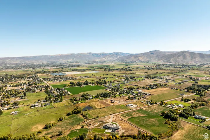 Aerial view of sparsely populated area featuring mountains and large plots for crops