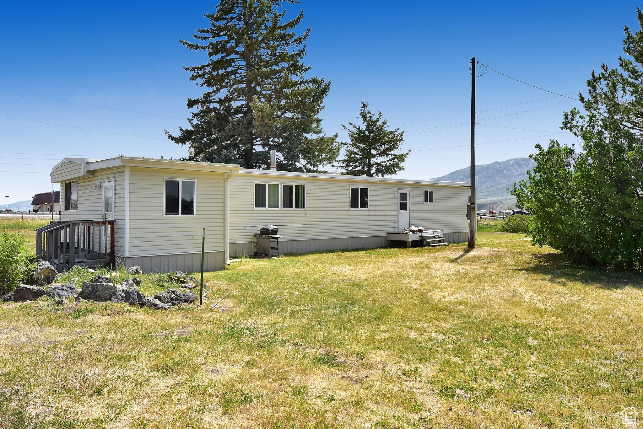 Rear view of property with a lawn and a mountain view