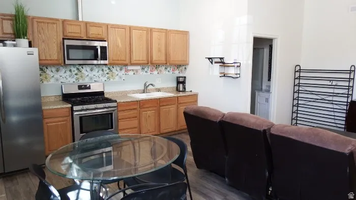 Kitchen featuring appliances with stainless steel finishes and dark wood-style flooring