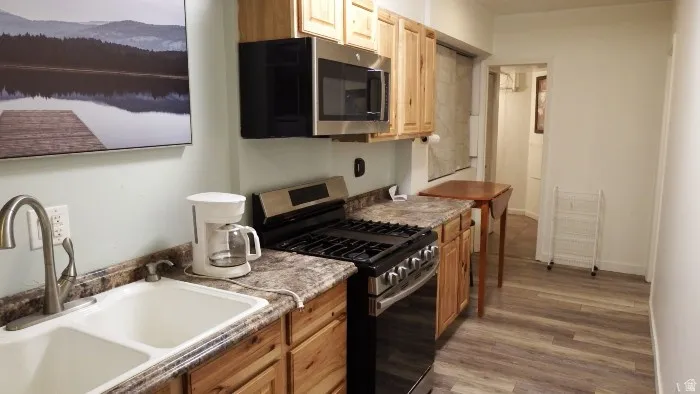 Kitchen featuring appliances with stainless steel finishes, light wood-style floors, and light brown cabinetry