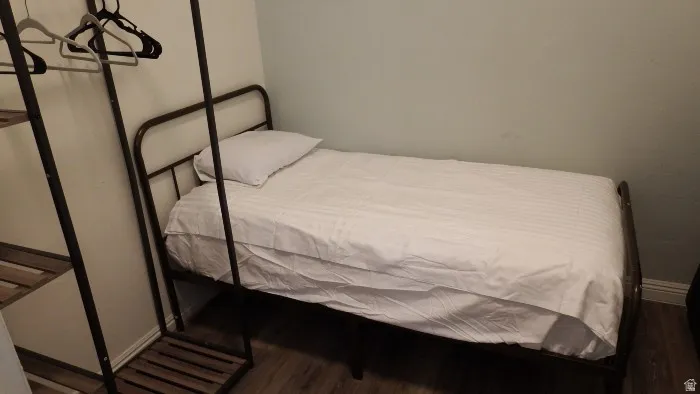 Bedroom with baseboards and dark wood-type flooring