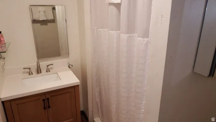Full bath with a shower stall and vanity