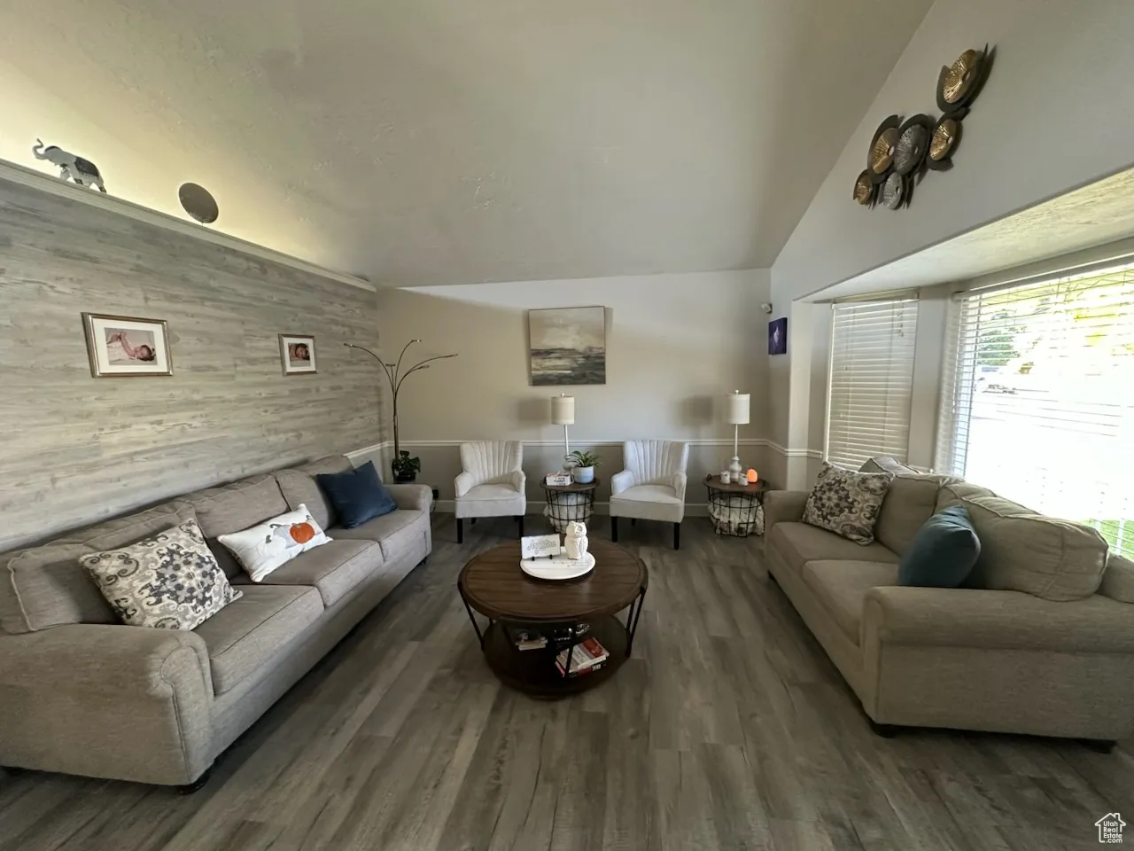Living area featuring wood finished floors, wood walls, and lofted ceiling