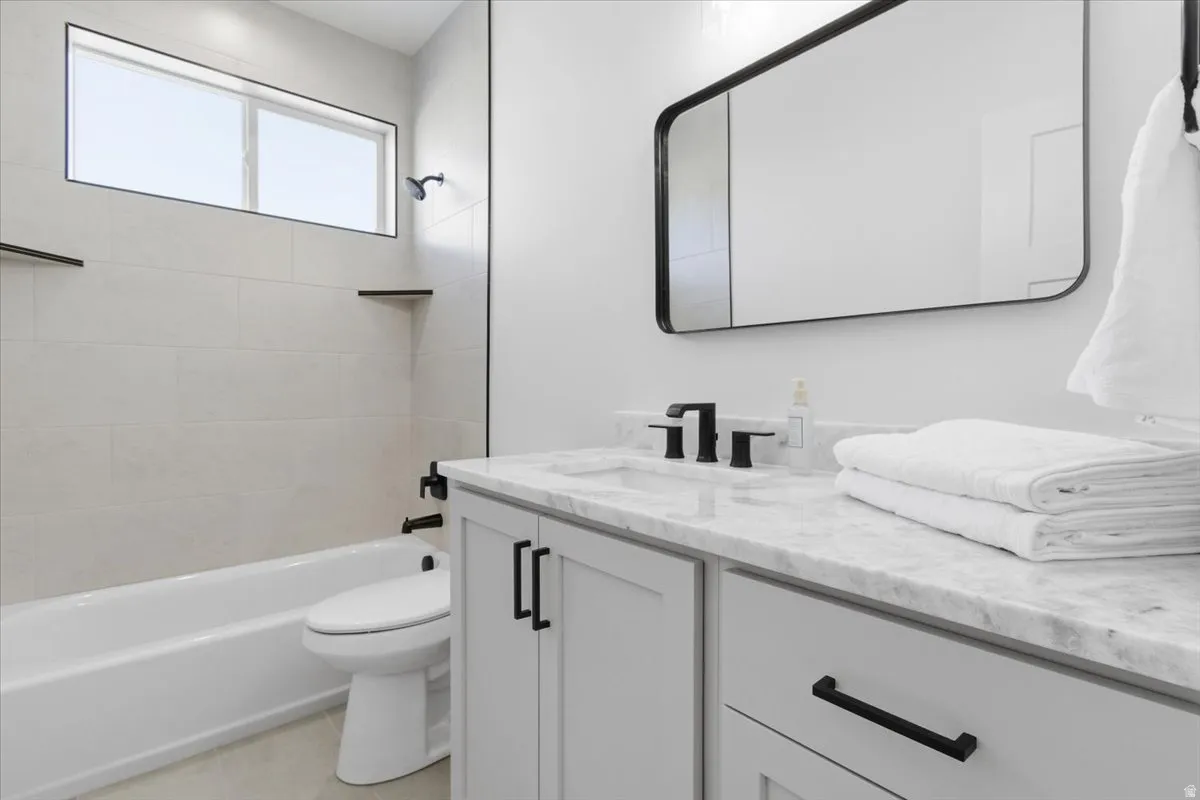 Full bath with vanity, bathtub / shower combination, and light tile patterned flooring