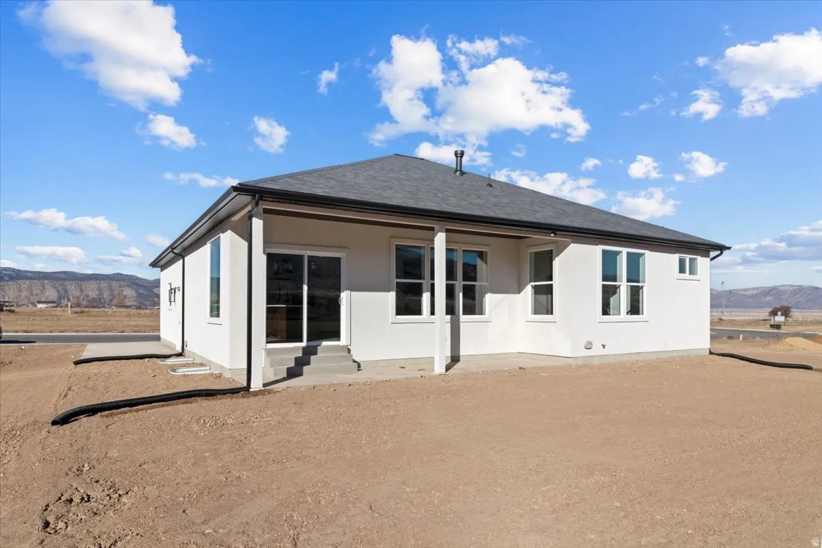 Rear view of property featuring a mountain view, a patio, and entry steps