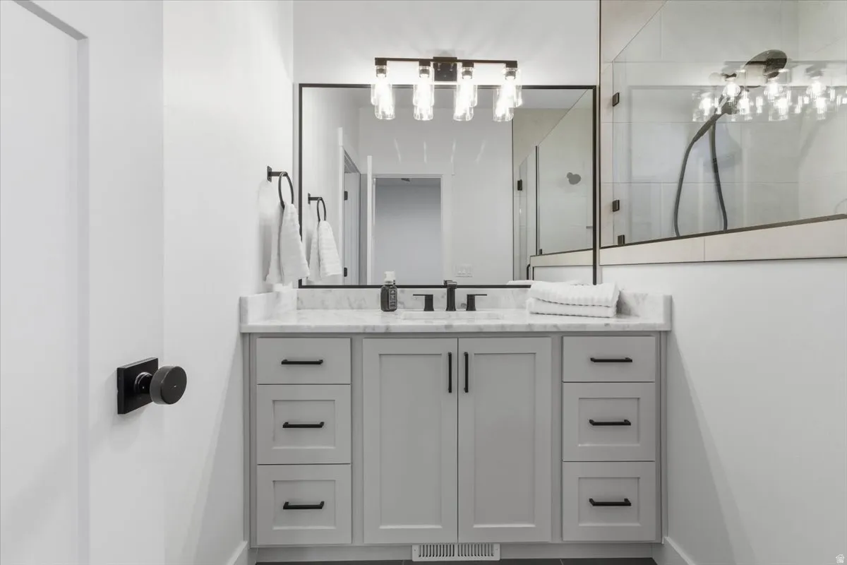 Bathroom with vanity and tiled shower