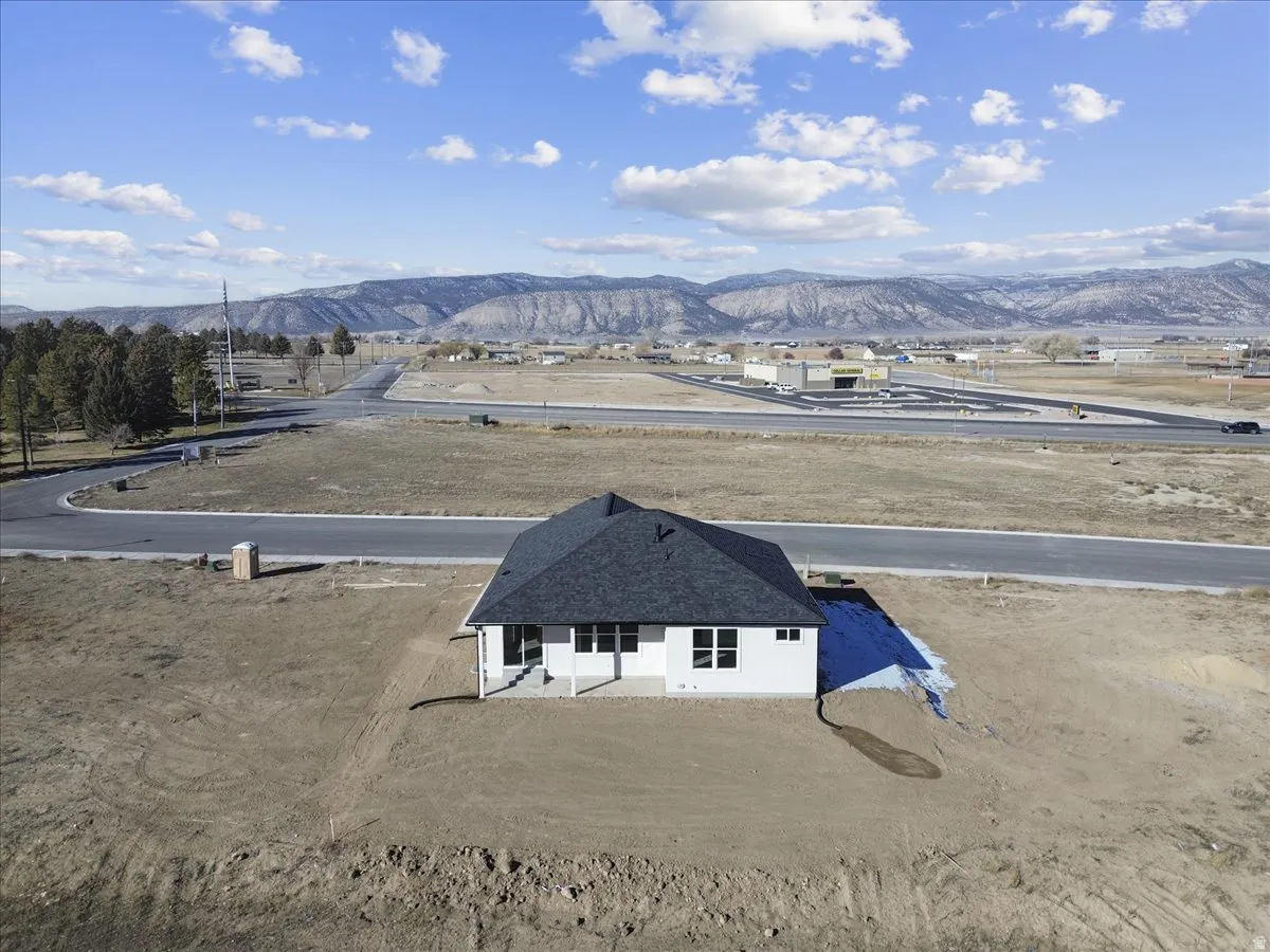 Aerial view of property and surrounding area featuring a mountain backdrop