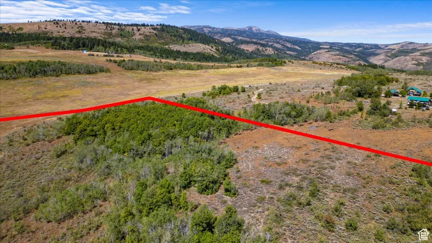 Aerial view of property's location with property boundaries highlighted and a mountain backdrop