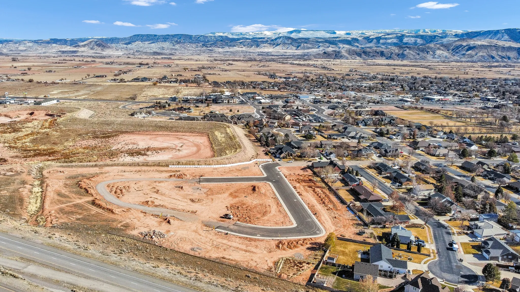 Aerial view of property's location featuring a mountain backdrop and nearby suburban area