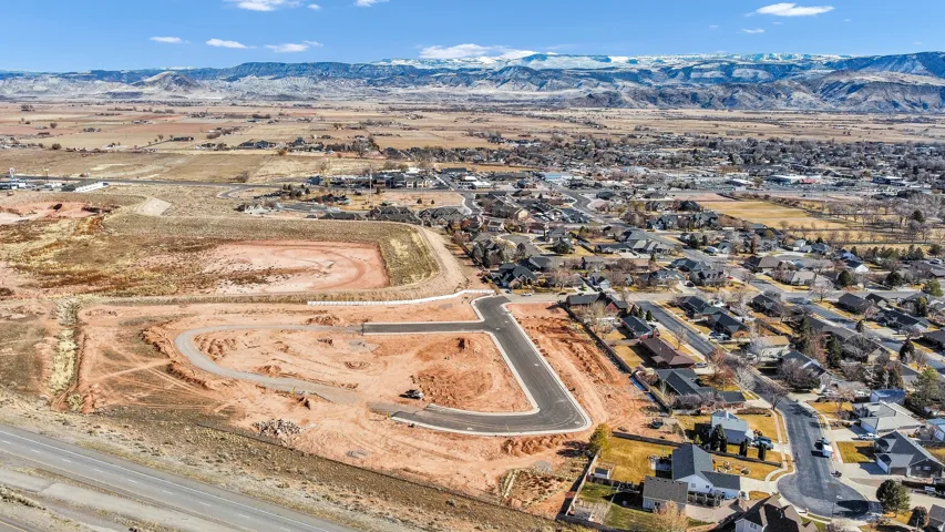 Aerial view of property's location featuring a mountain backdrop and nearby suburban area