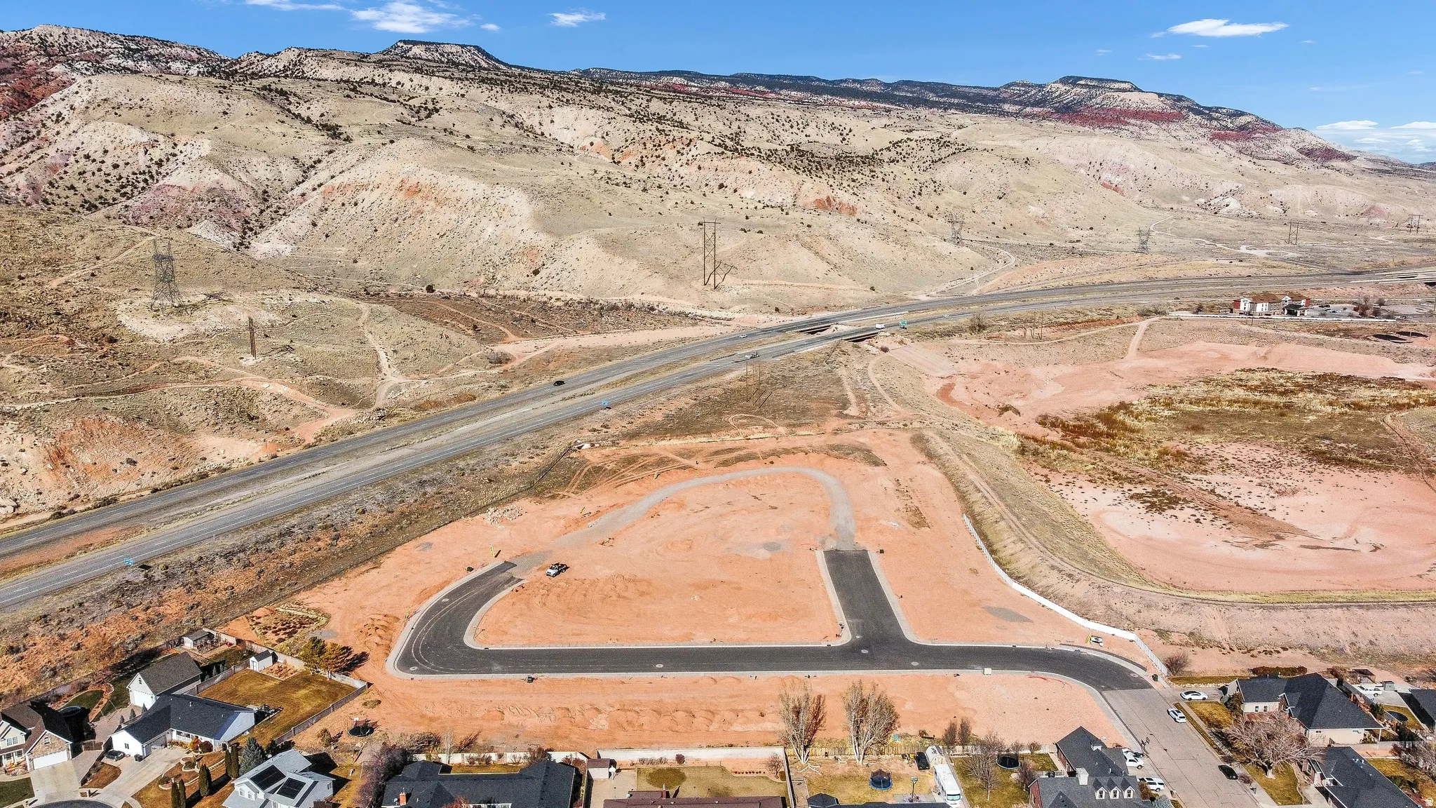 Aerial perspective of suburban area featuring a mountainous background and a desert landscape