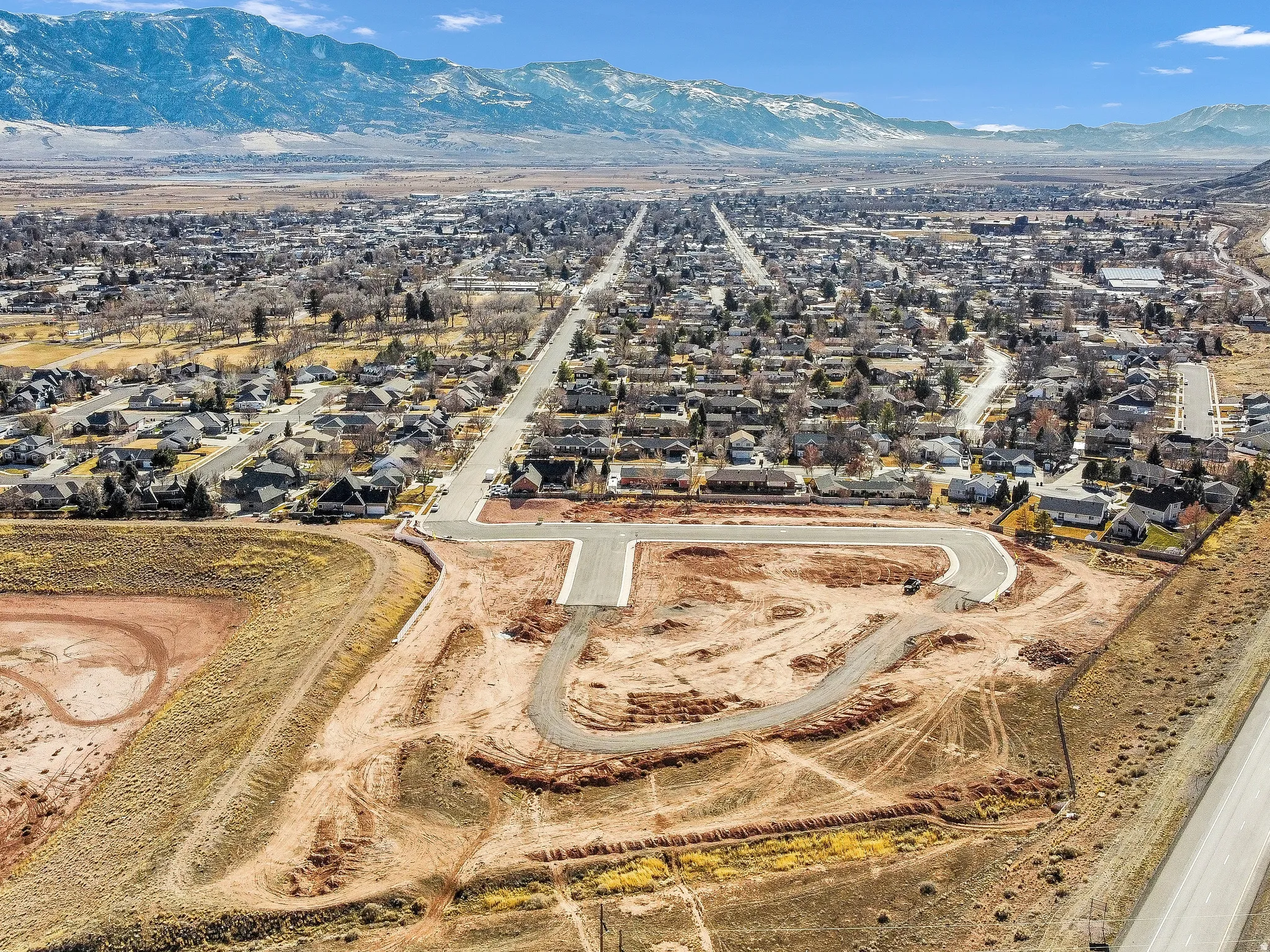 Aerial overview of property's location featuring a mountain backdrop and nearby suburban area