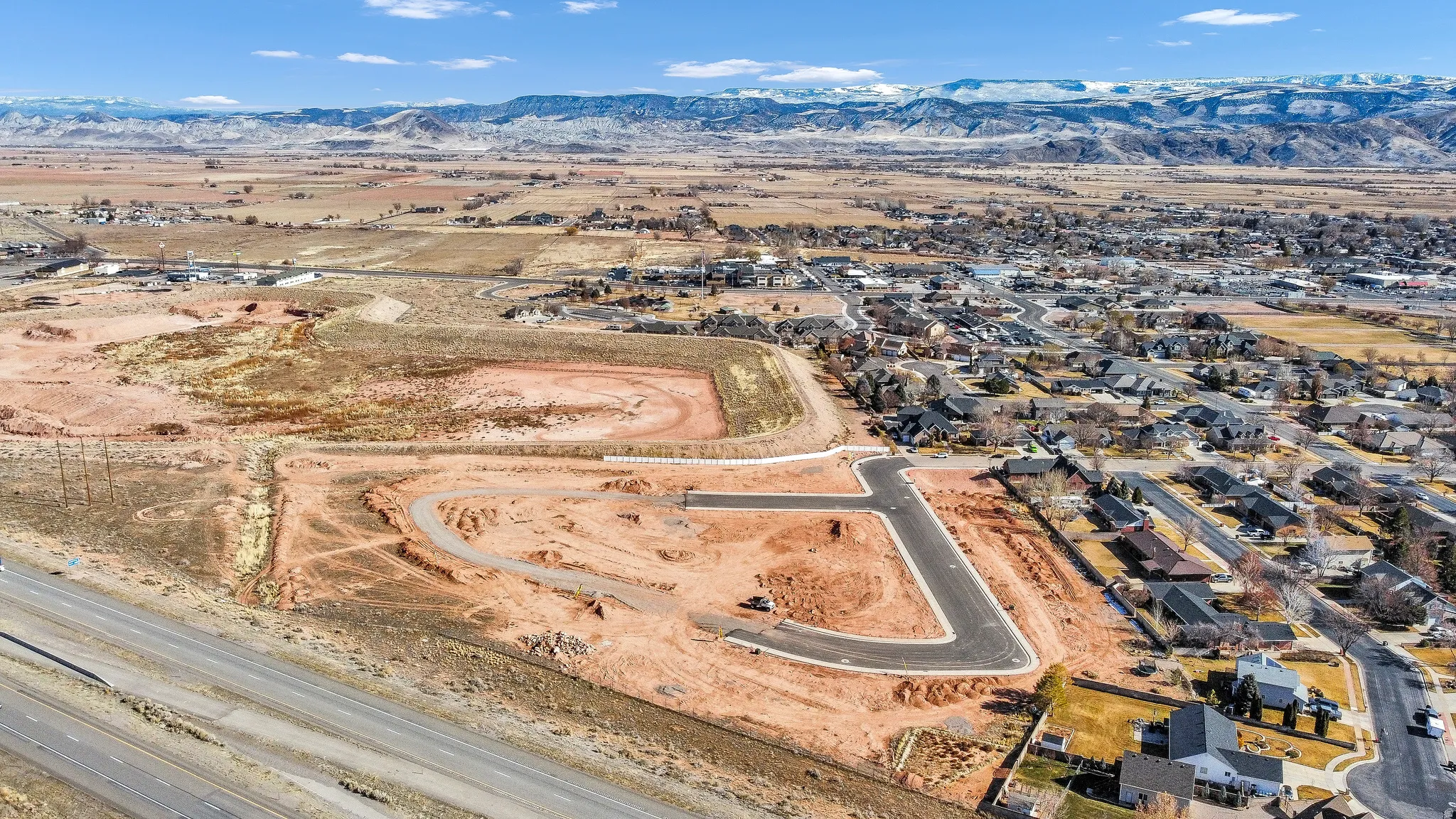 View of property location with a mountain backdrop and nearby suburban area