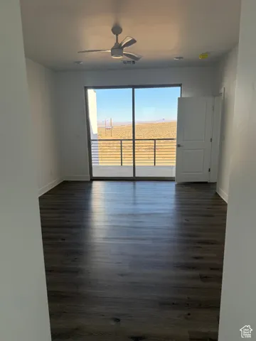 Unfurnished room with dark wood-style floors and a ceiling fan