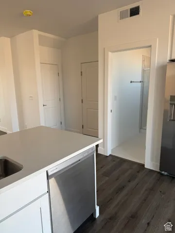 Kitchen featuring white cabinetry, appliances with stainless steel finishes, and dark wood-style flooring