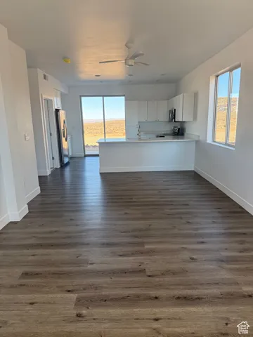 Kitchen featuring light countertops, open floor plan, white cabinetry, a peninsula, and plenty of natural light