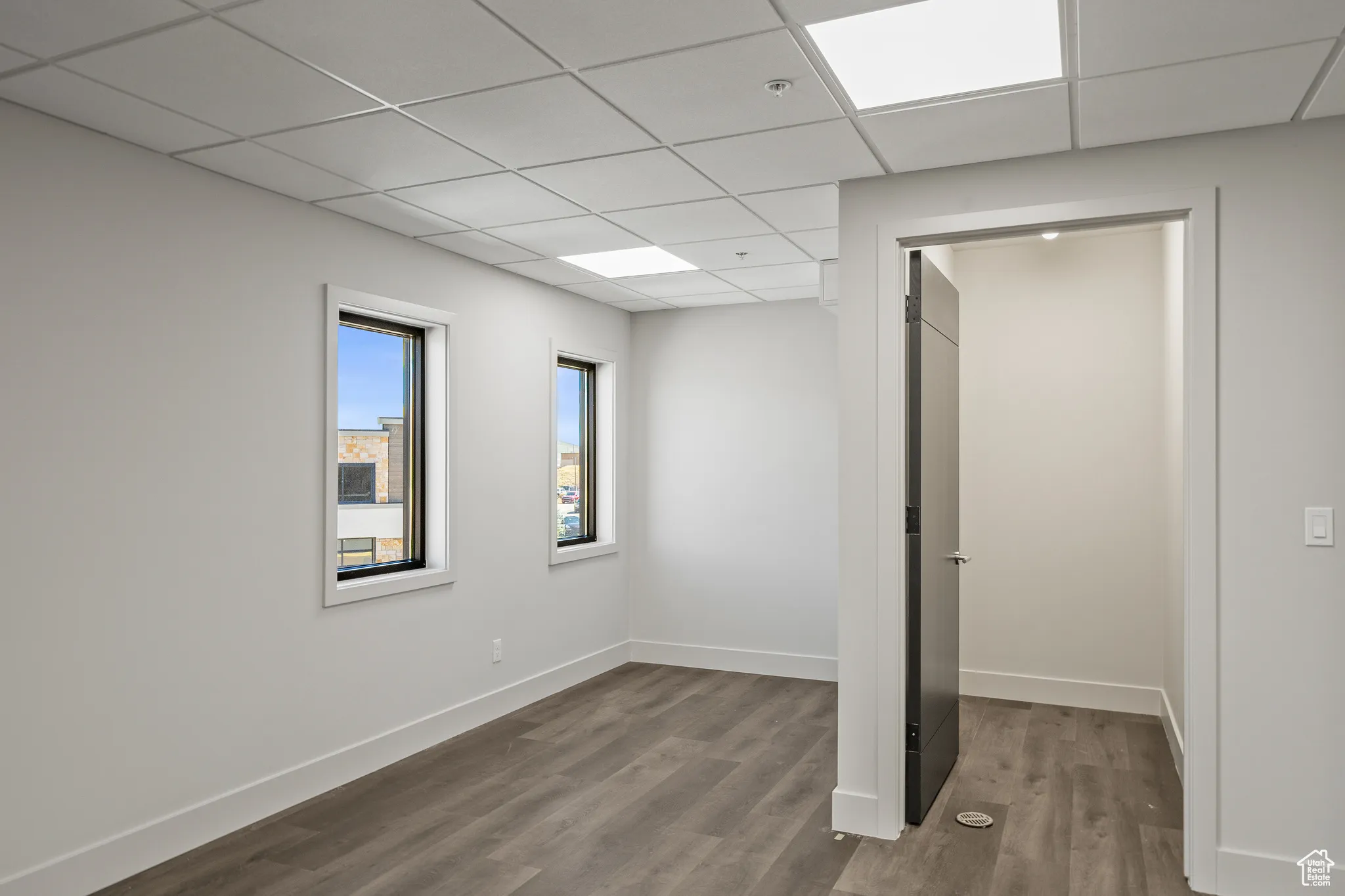 Unfurnished bedroom featuring a paneled ceiling and wood finished floors