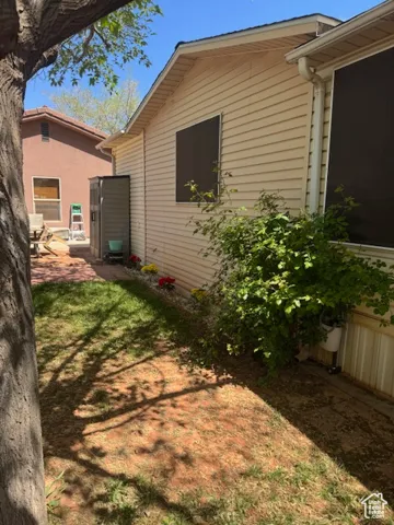 View of property exterior with a lawn and a patio area