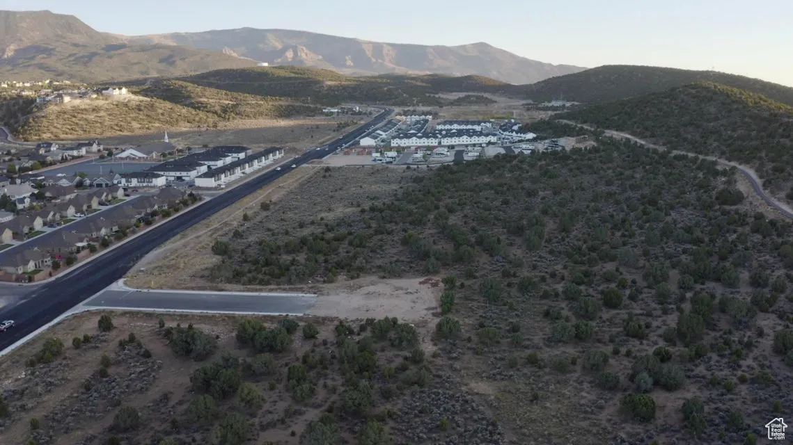 Aerial view of property and surrounding area featuring a mountain backdrop