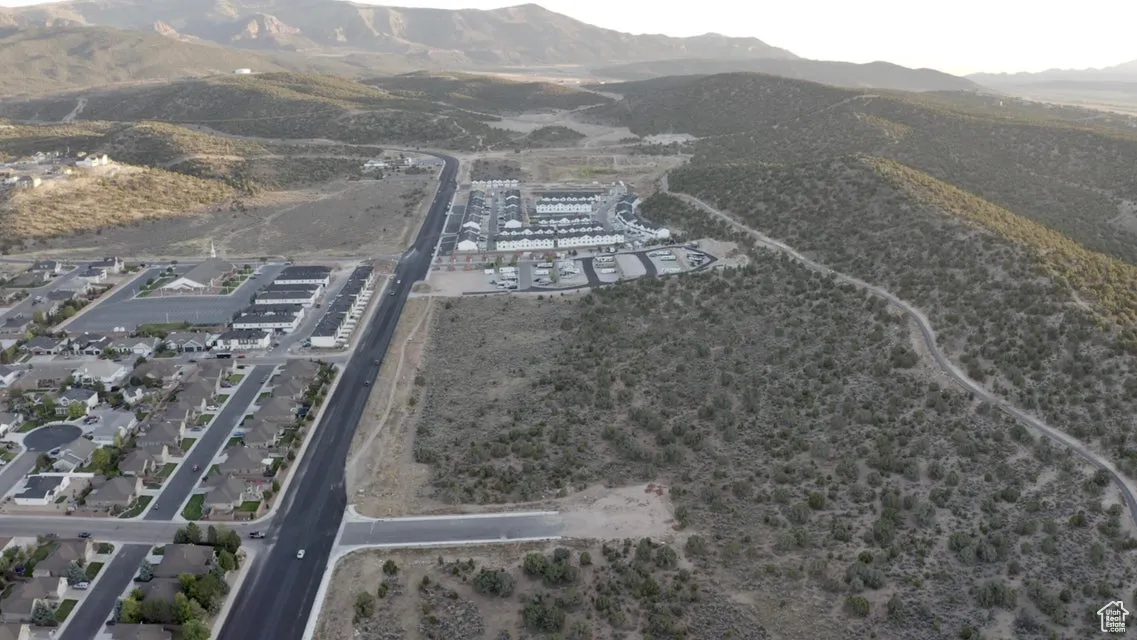 Aerial view of property and surrounding area with a mountainous background