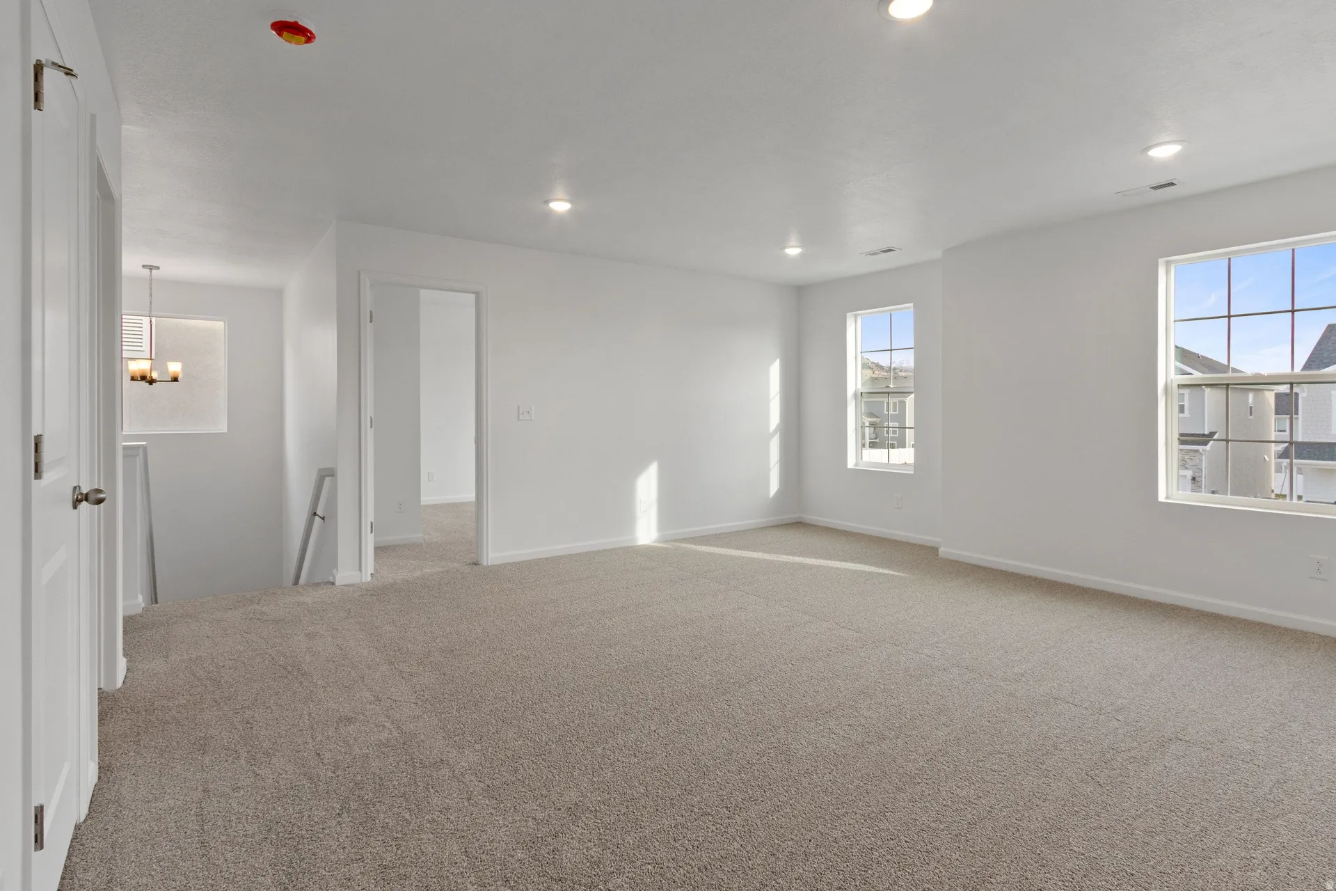 Upstairs loft featuring light carpet and recessed lighting
