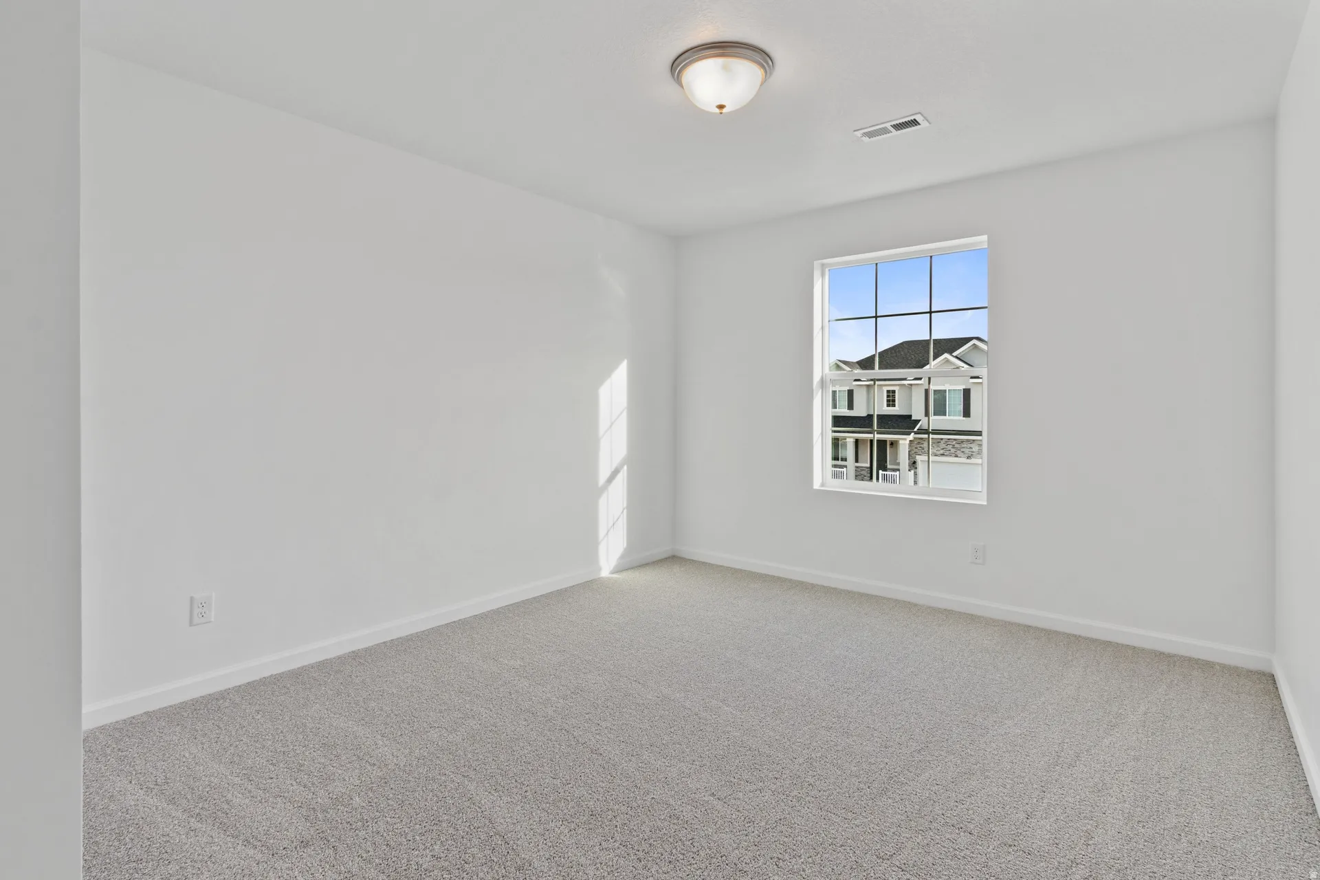 Empty room featuring light carpet and baseboards