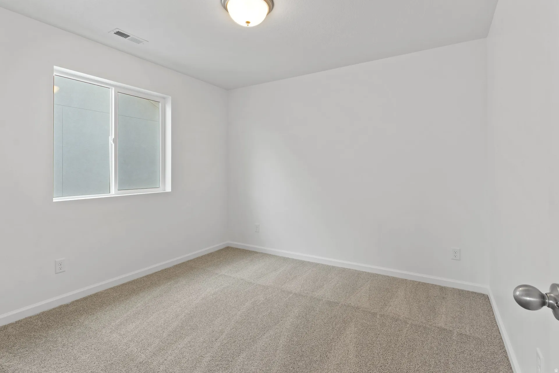 Unfurnished room with baseboards and light carpet