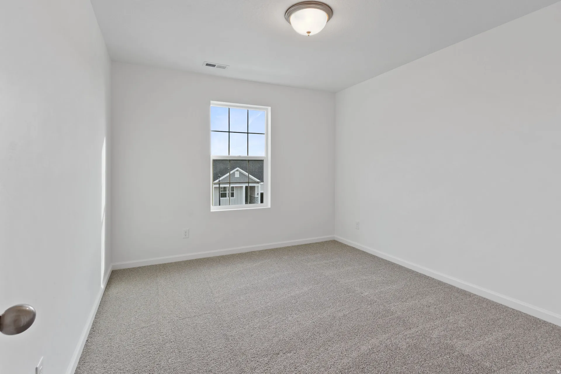 Spare room featuring baseboards and light colored carpet