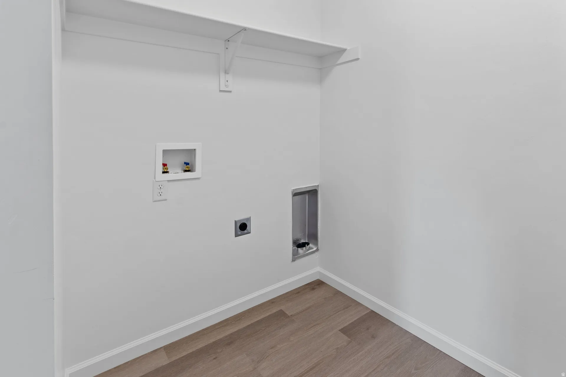 Laundry area featuring washer hookup, light wood-style floors, and electric dryer hookup