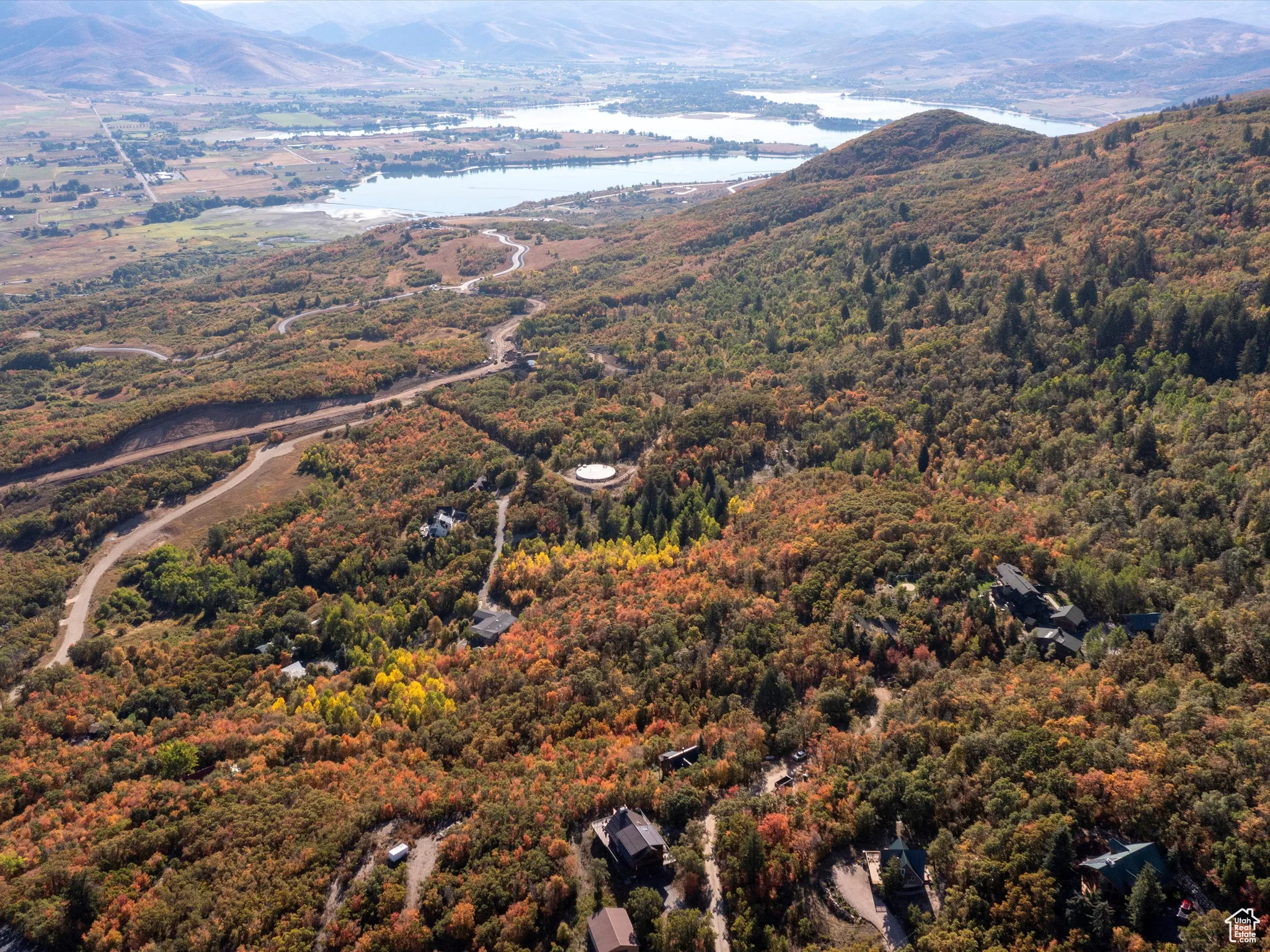 Drone / aerial view of a water and mountain view and a heavily wooded area