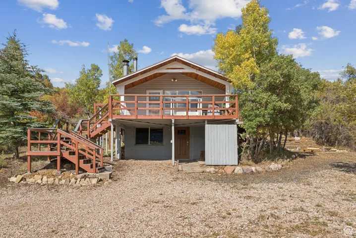 Rear view of property with a deck and stairway