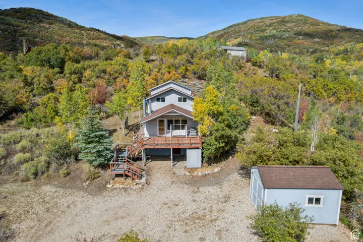 View of subject property featuring mountains and a heavily wooded area