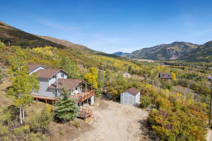 View from above of property featuring a mountainous background and a forest