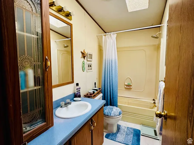 Bathroom with vanity,  shower / tub combo and a skylight