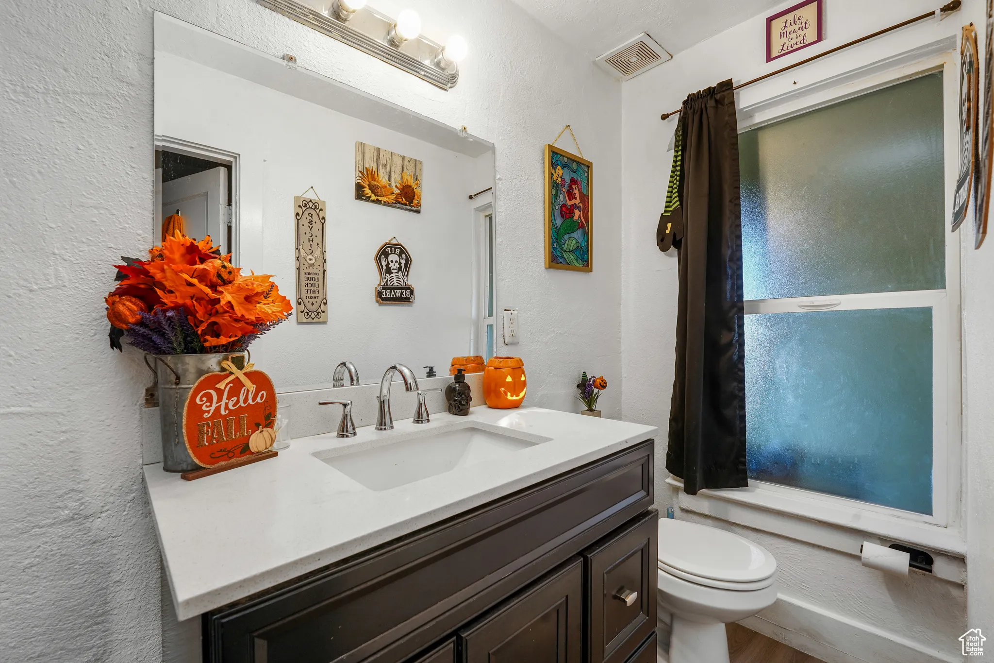 Bathroom with a textured wall and vanity