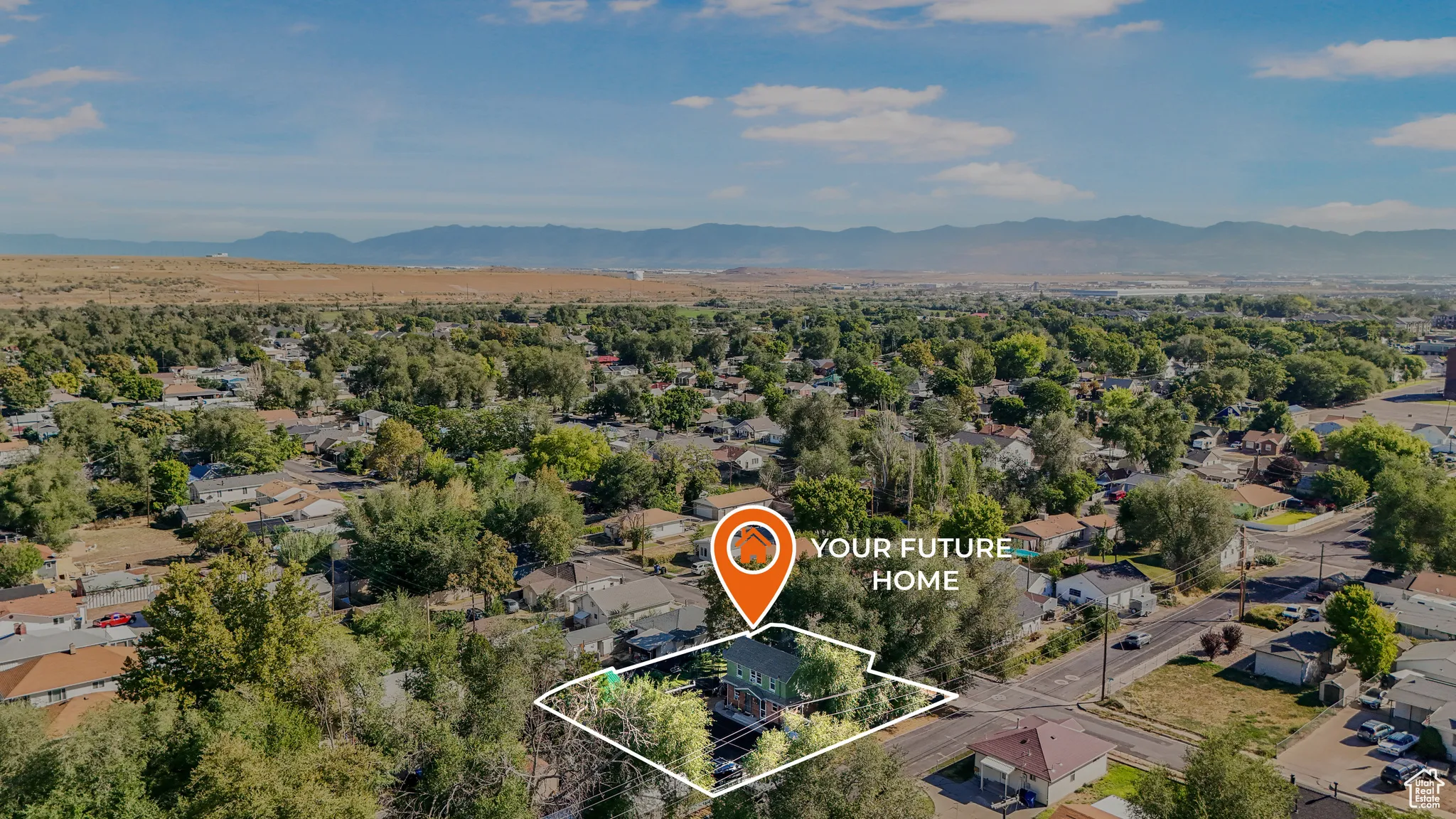 Aerial view of residential area featuring a mountain backdrop and property boundaries highlighted