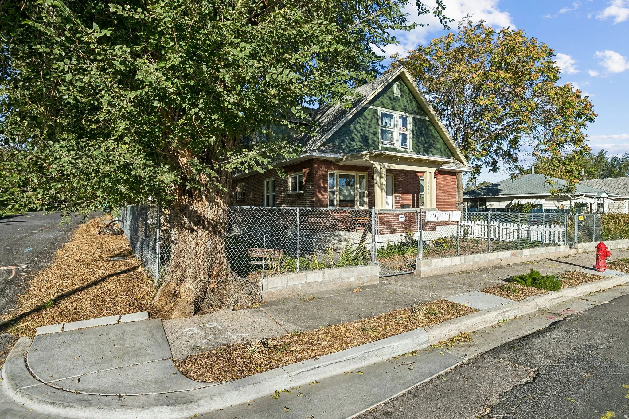 View of front of home featuring a gate, a fenced front yard, a porch, and brick siding