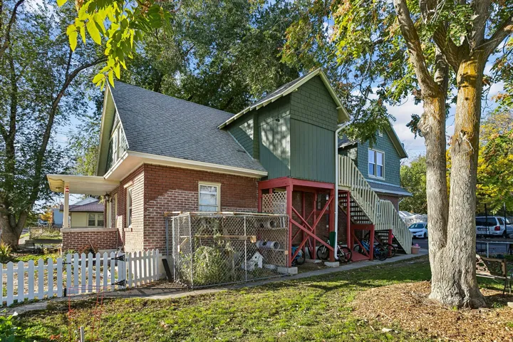 View of front of home featuring roof with shingles and brick siding