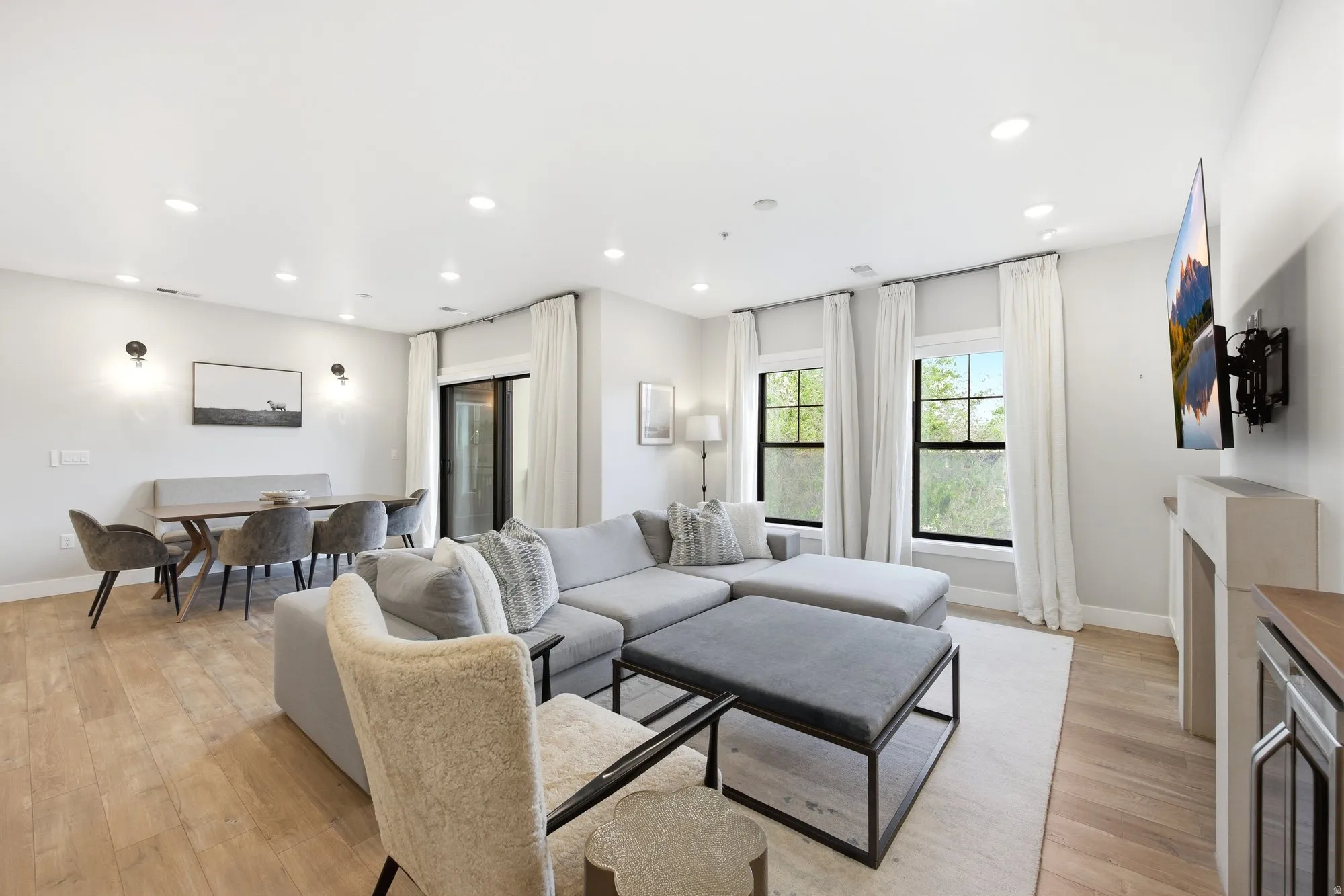 Living area with light wood-type flooring and recessed lighting