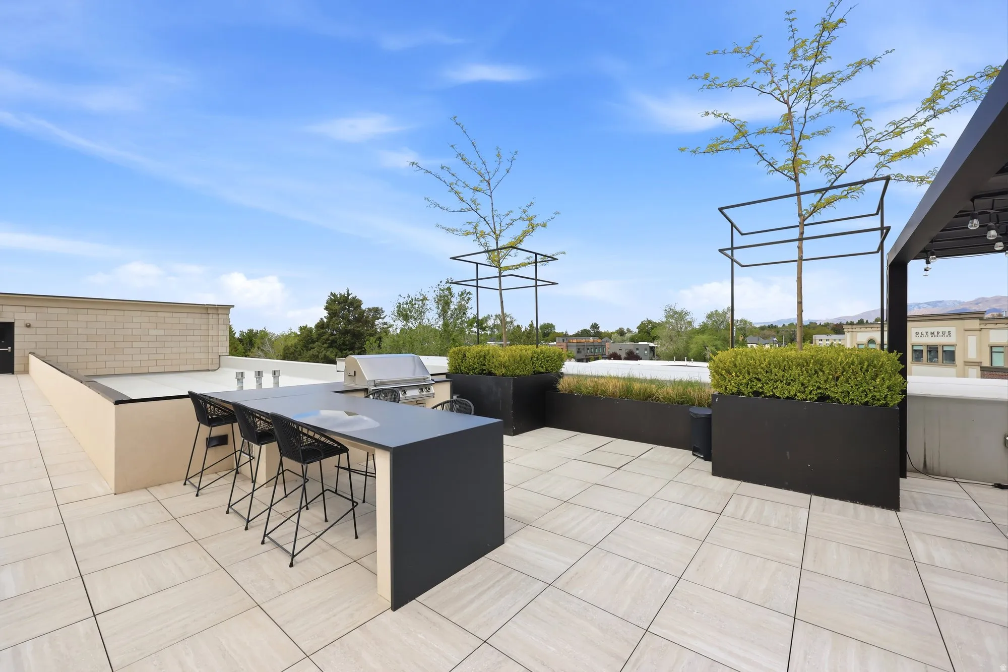 View of patio with area for grilling and a mountain view
