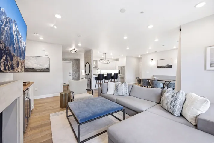 Living area with light wood-type flooring and recessed lighting