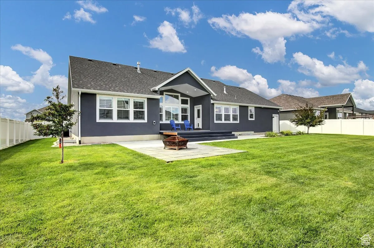 Back of property with a patio, an outdoor fire pit, stucco siding, and a shingled roof