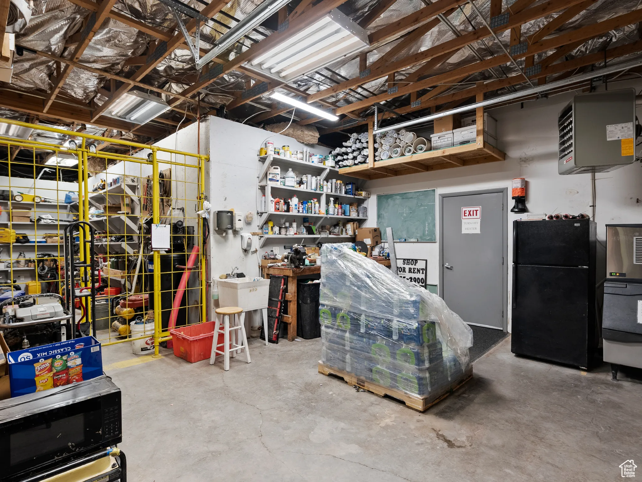 Below grade area with freestanding refrigerator and a heating unit