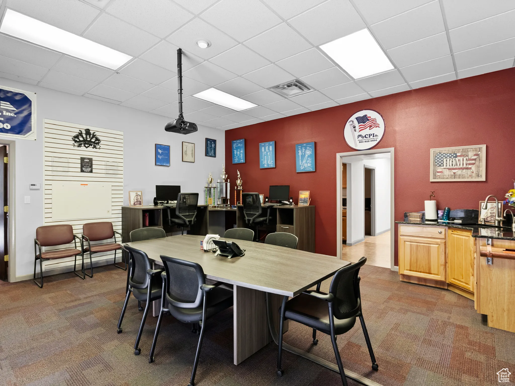 Dining room with dark colored carpet, a drop ceiling, and an office area