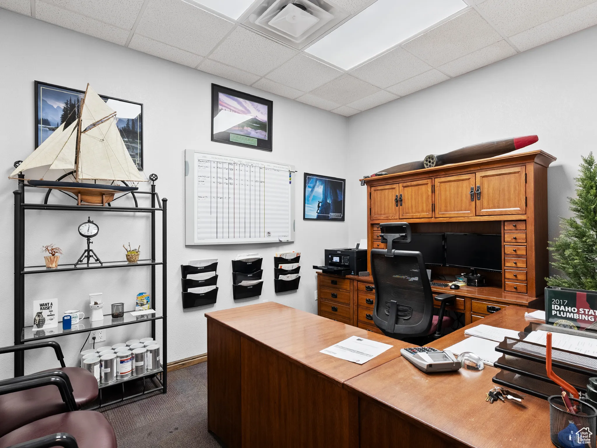 Home office featuring dark colored carpet and a drop ceiling