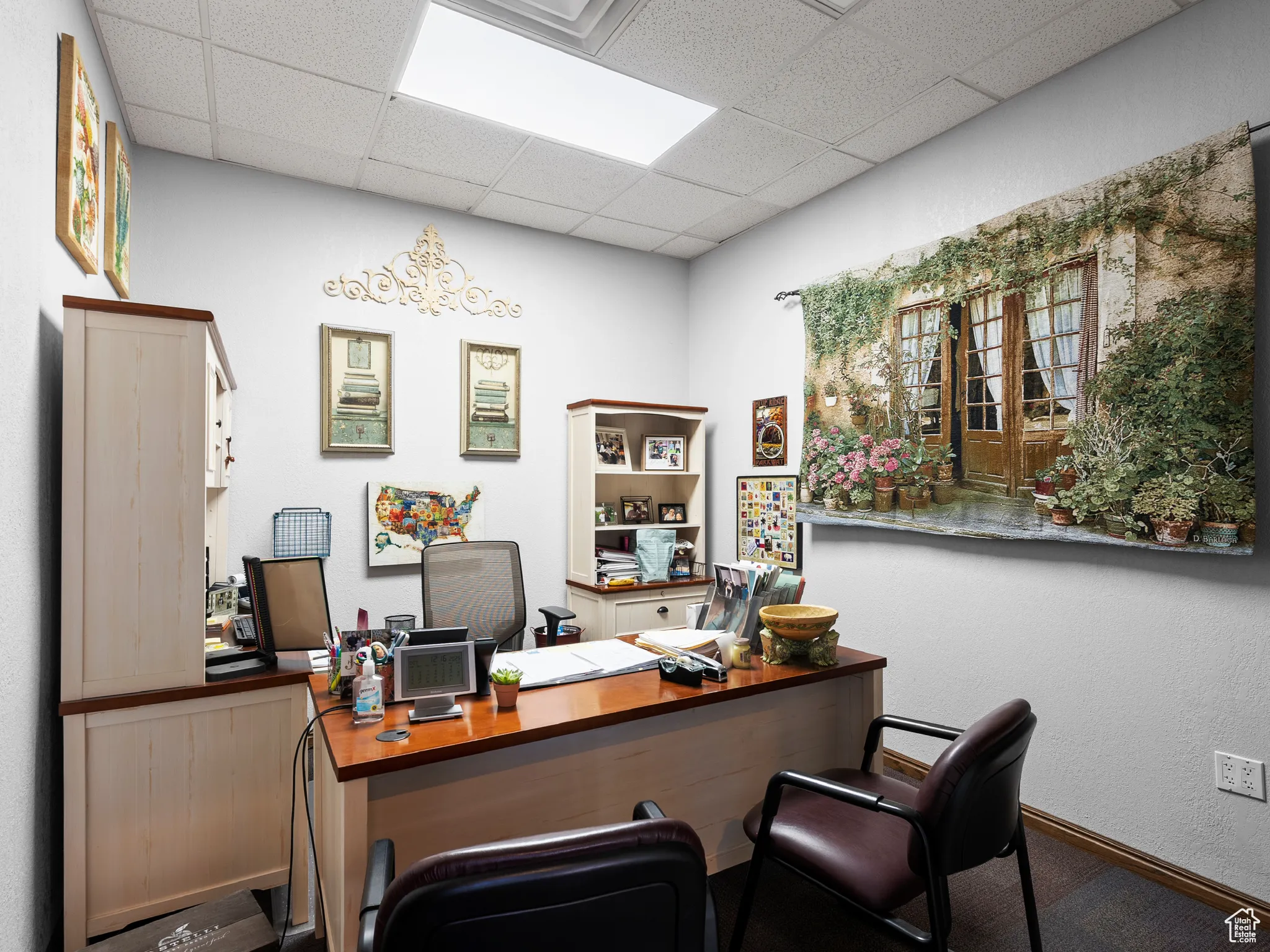 Office area featuring a drop ceiling and a textured wall