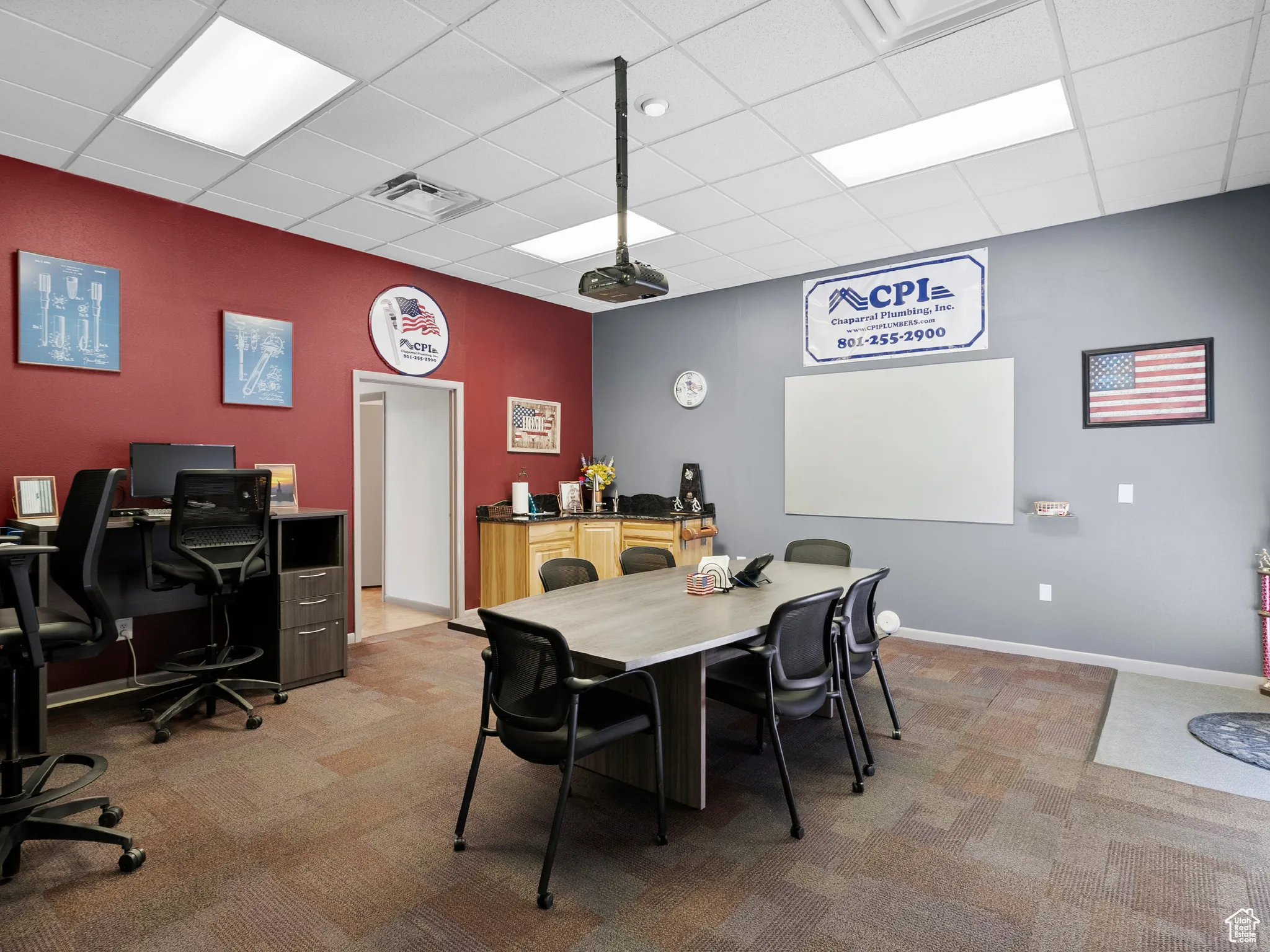 Dining space with a desk, light colored carpet, and a drop ceiling